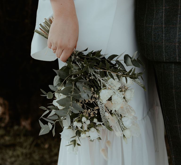 White flower bouquet with green leaf foliage, roses and bunny grass for minimal winter wedding at Christmas 