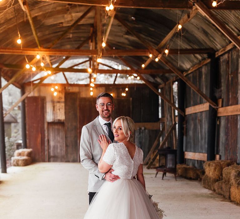 The bride and groom pose together for cute couple portraits on their winter wedding day