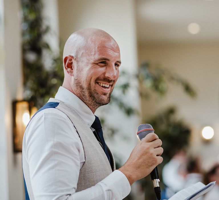 The groom stands to read out his wedding speech to the guests 