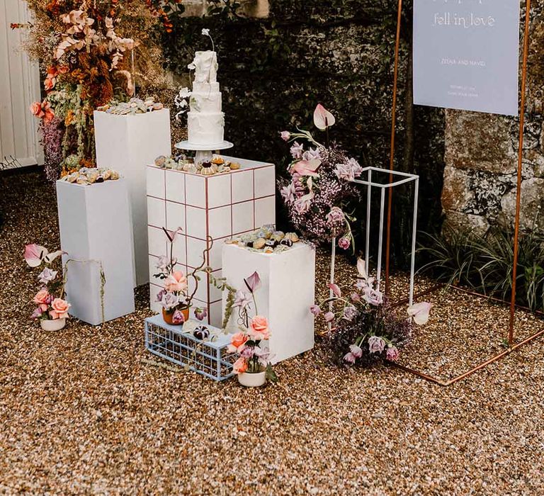 Wedding cake stand, column flowers and wedding sign at chapel house estate wedding venue in Kent 