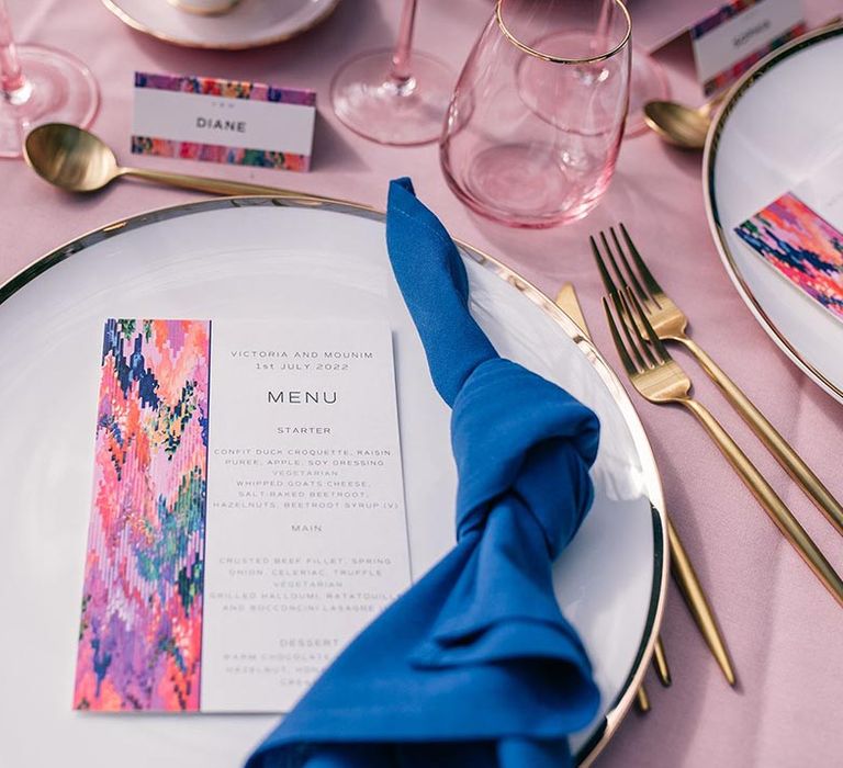 White gold edged plate with dark blue napkin, gold cutlery, and wedding menu designed by Papier 