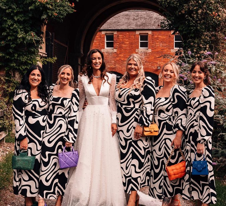 Square neck puff sleeve patterned monochrome bridesmaid dresses with colourful bags and shoes with the bride in pearl long sleeve wedding dress