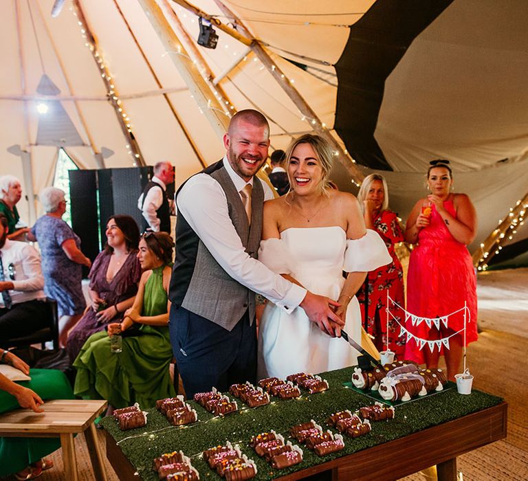 The bride and groom cut their Colin the Caterpillar wedding cakes 