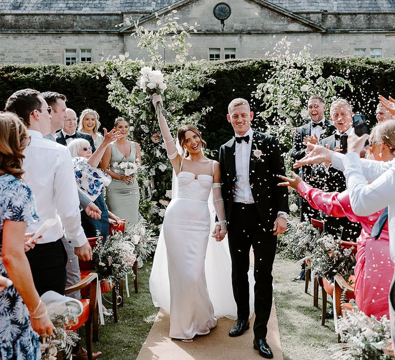 Confetti exit for couple at outdoor wedding ceremony 