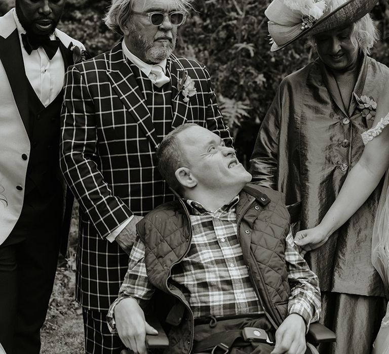 Black and white wedding family photo with the bride's brother smiling at her 