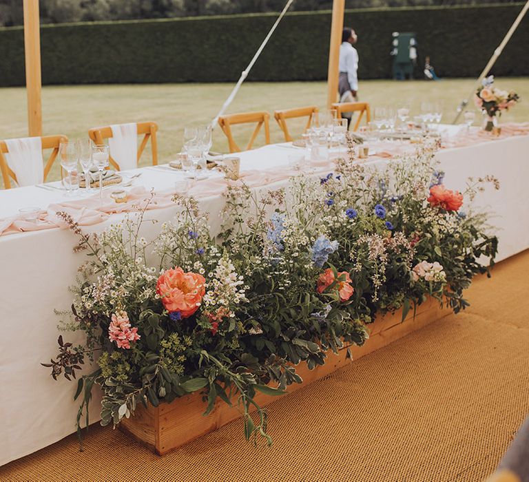 Colourful summer wedding flowers with lots of foliage and wildflowers to match the season at marquee wedding 