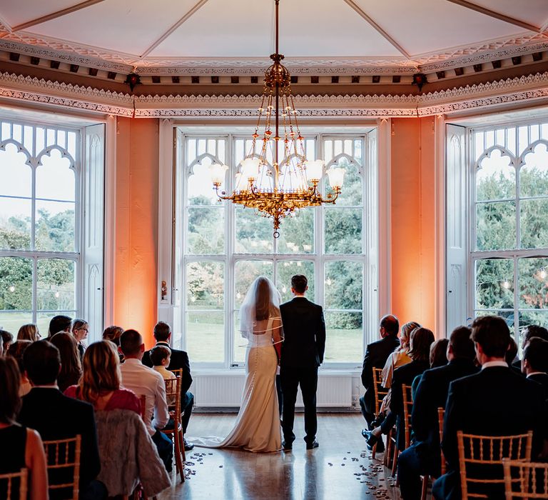 Traditional civil wedding ceremony at Nonsuch Mansion wedding venue in Cheam with chandelier 