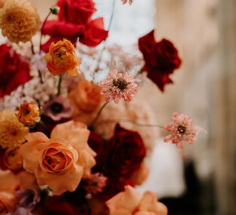 Red, orange and pink bold colourful wedding flowers with roses 