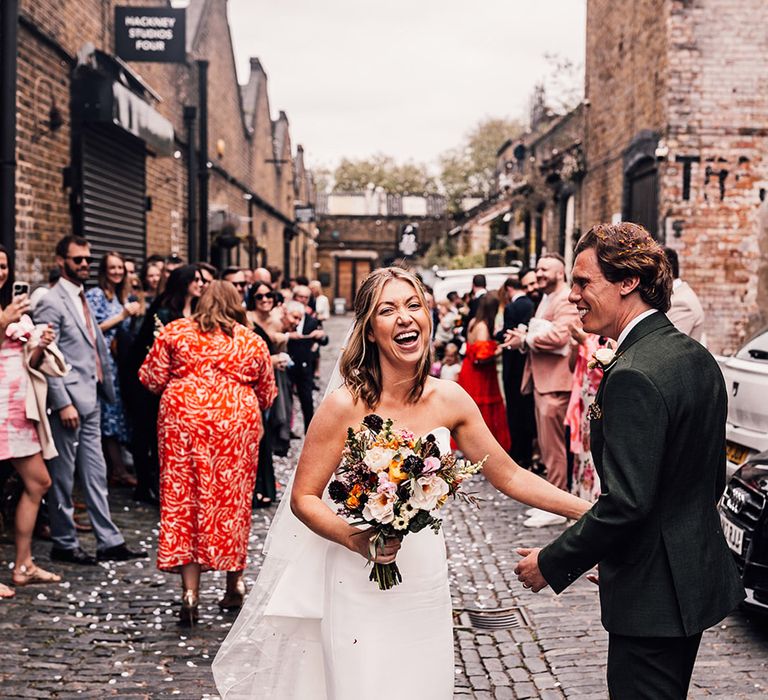 London city weddig with the bride in a strapless wedding dress and groom walking together 