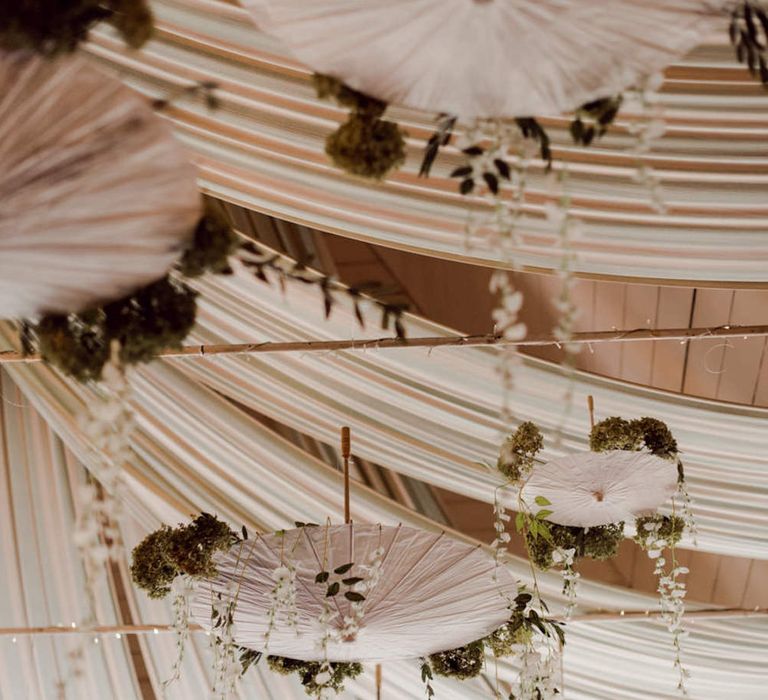 White umbrella decor from the bride and grooms travels