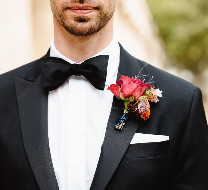 Red buttonhole at Autumn black tie wedding