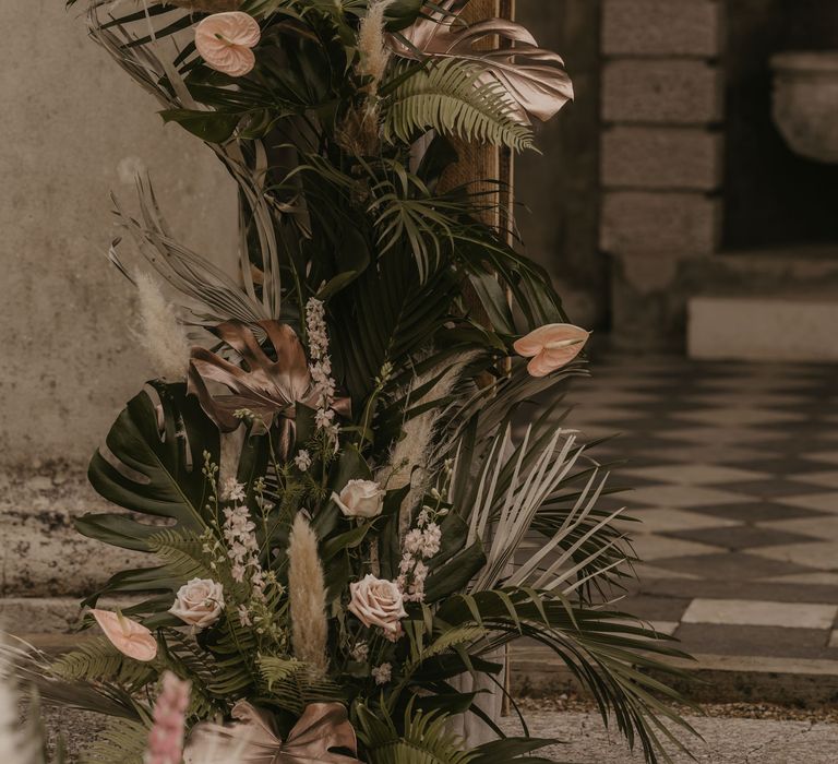 tropical wedding flower arrangements with palm leaves, pampas grass and anthuriums