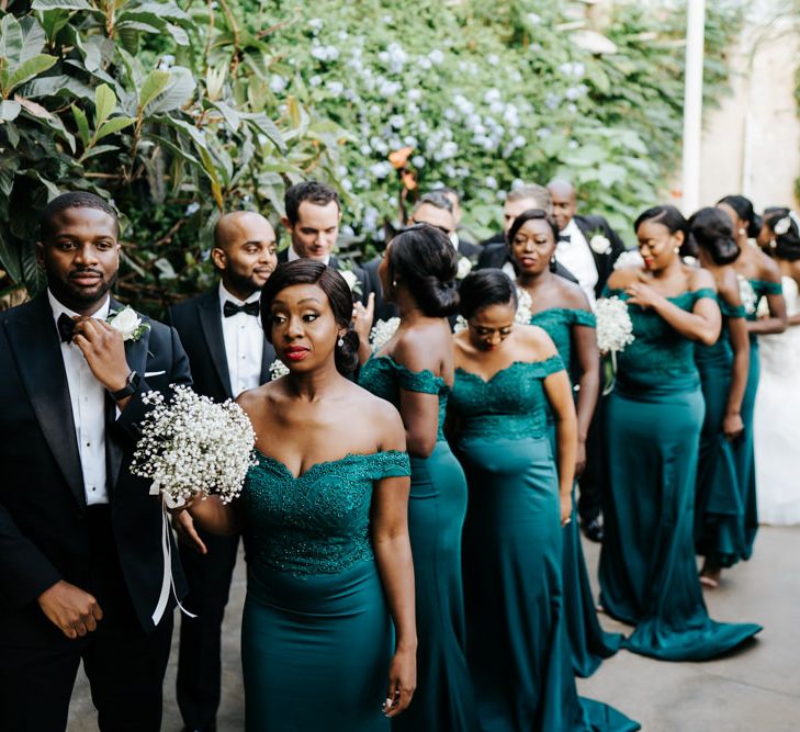 Wedding party lineup with bridesmaids in strapless green dresses and tuxedos 