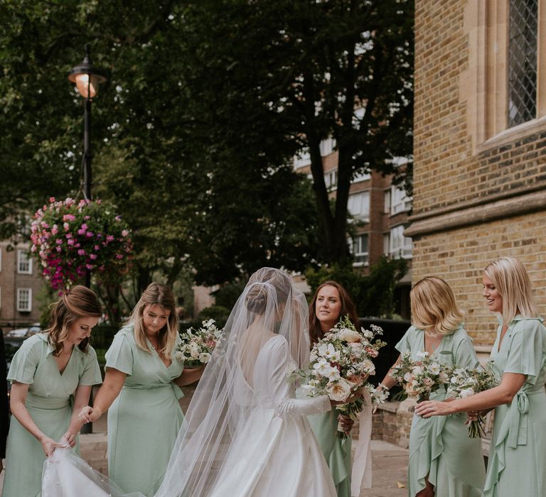 Spring colours for London wedding bride with her bridesmaids getting ready to walk into church 