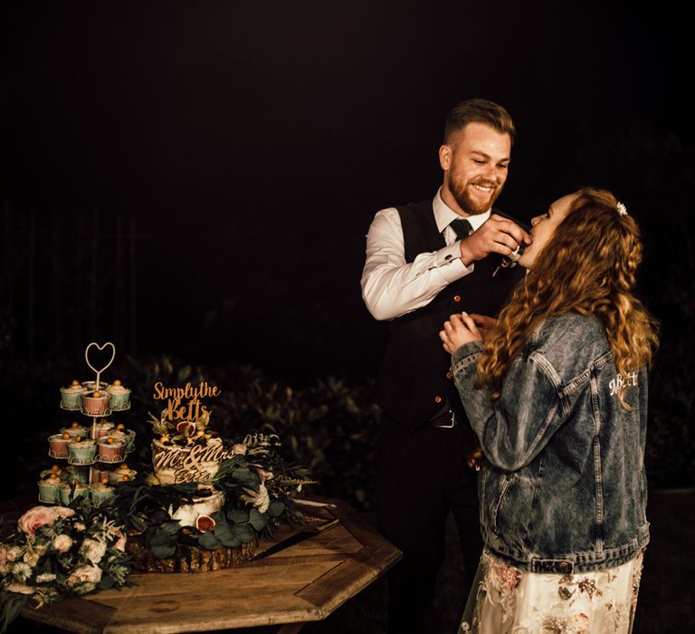 Bride & groom feed each other wedding cake 