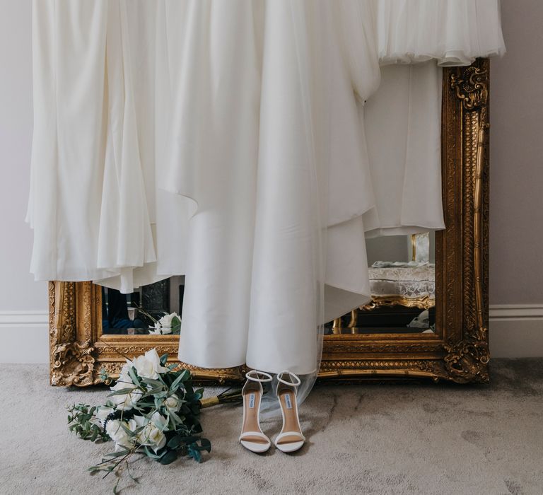 White high street bridesmaid dresses hanging on a mirror 