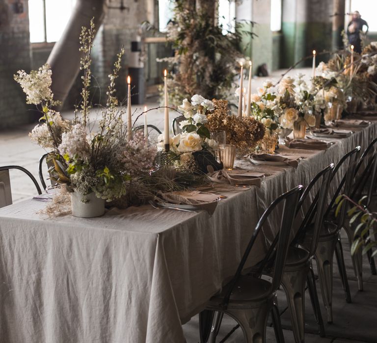 Intimate banquet table with taper candles, grey linen table cloth and floral centrepieces 