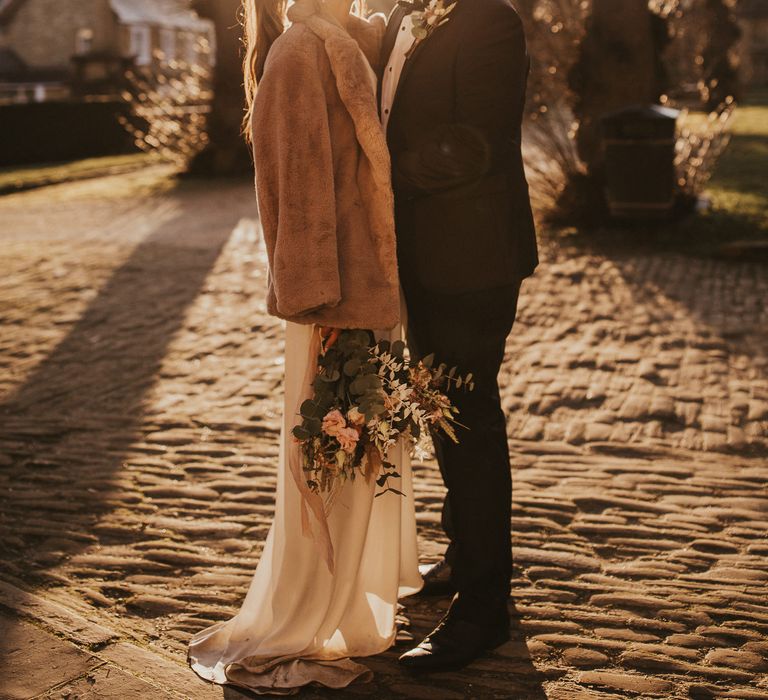 Bride & groom kiss during golden hour 