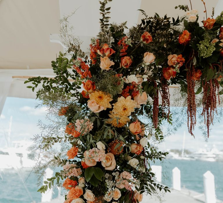 Orange, coral and blush pink and peach wedding flowers for floral arch 