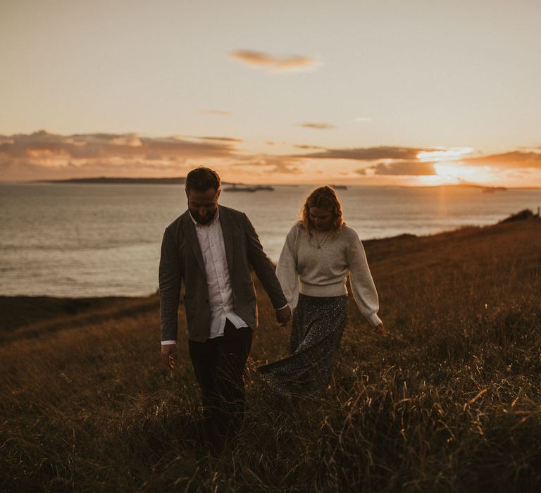 Bride and groom walk on the beach for engagement shoot