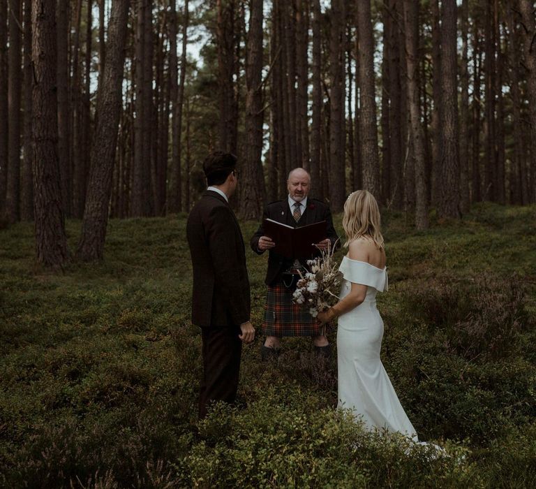 Bride & groom during handfasting ceremony outdoors in Scotland