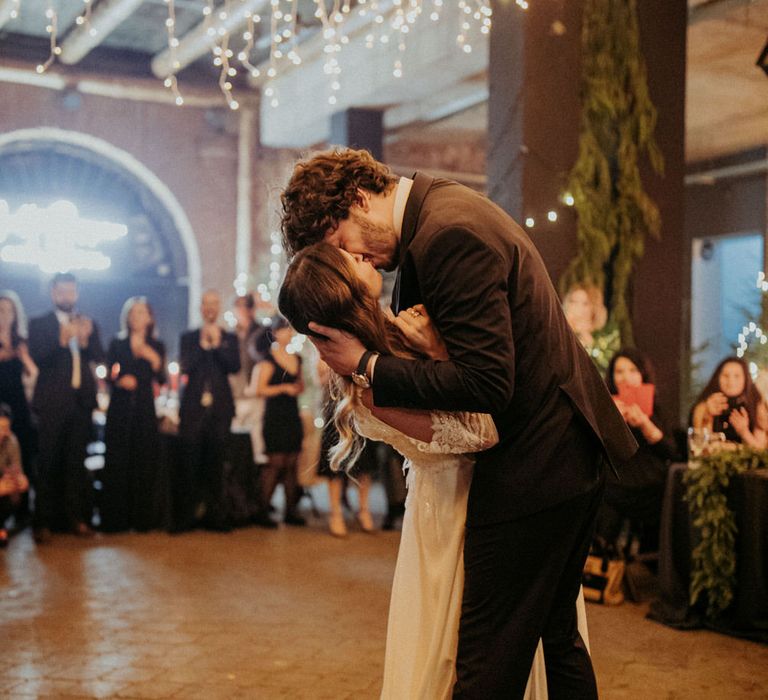 The groom dipping the bride on the dance floor for a kiss