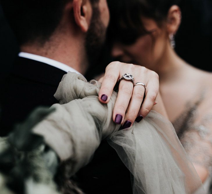 A close up shot of a deep purple manicure on a bride.