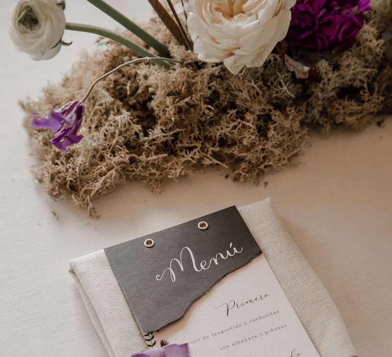 Menu card on a linen napkin tied with purple ribbon 