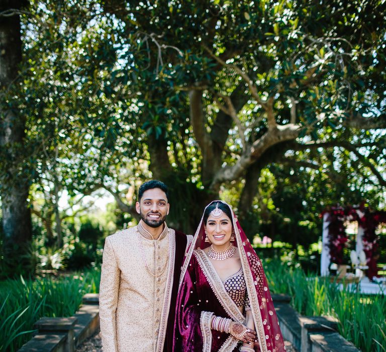 Bride & groom stand with one another on their wedding day outdoors