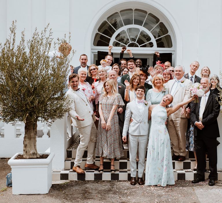 Bride & groom celebrate with their wedding party outside the Belair House