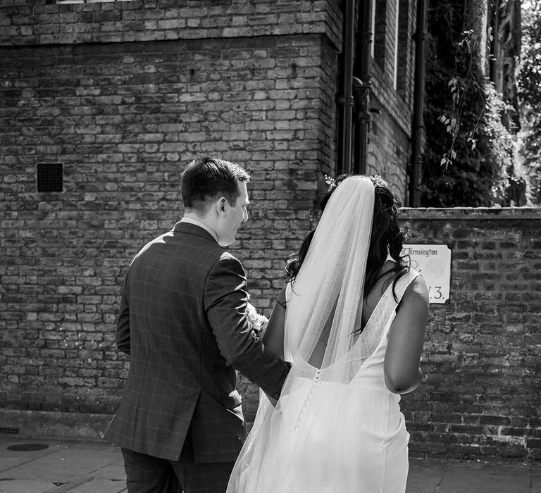 Bride & groom walk away together in black & white image