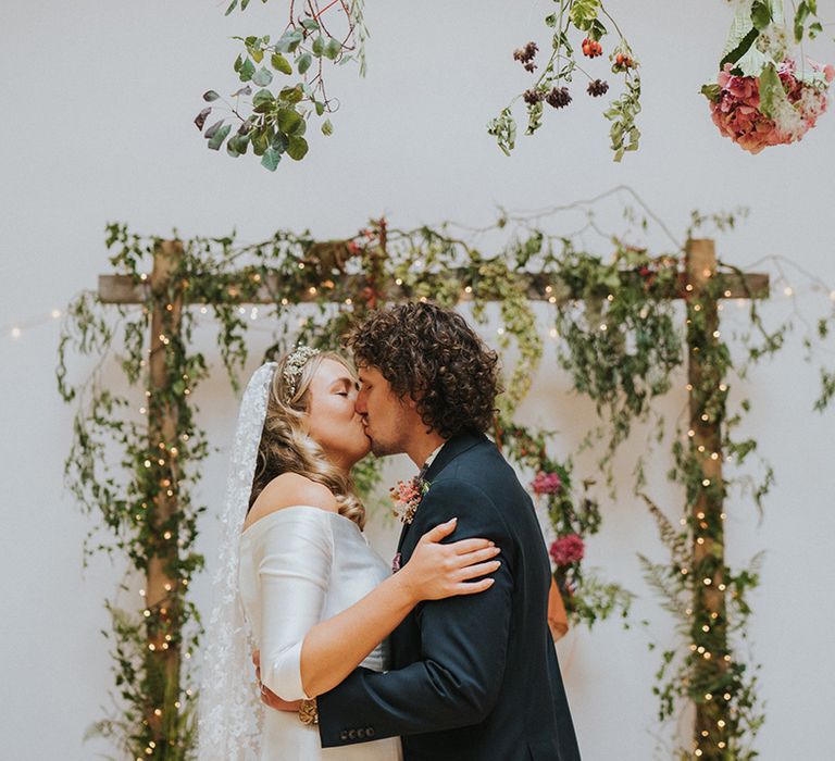 Bride & groom kiss on their wedding day during wedding ceremony