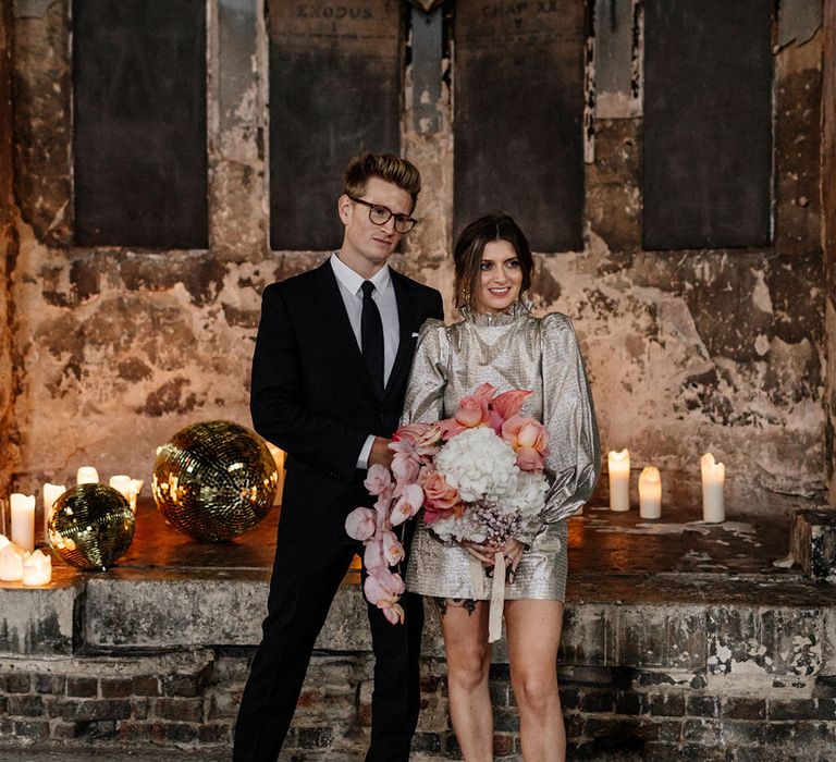 Urban Bride and Groom in Chapel wedding with disco balls and candles The Asylum London industrial themed wedding 