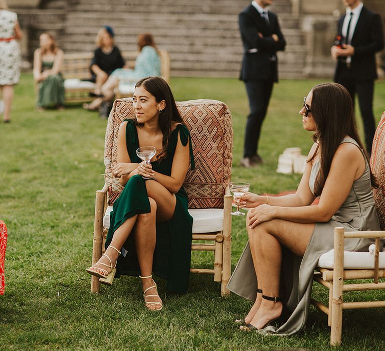 Bridesmaids sits outdoors 