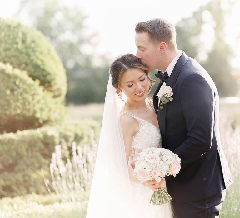 Groom kisses his bride outdoors on the day of their wedding