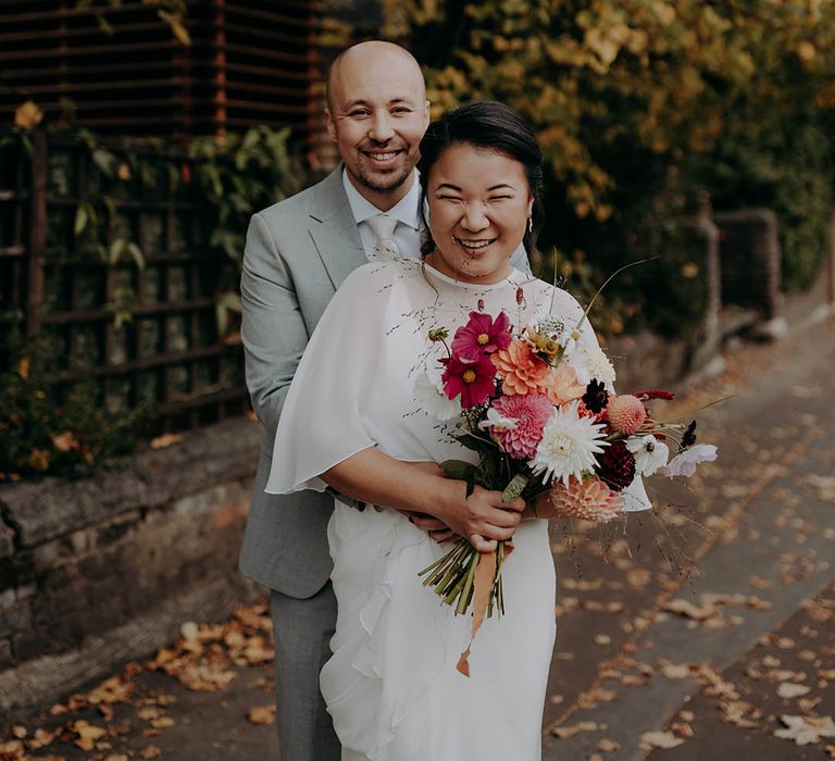 Groom wraps his arms around his bride on their wedding day