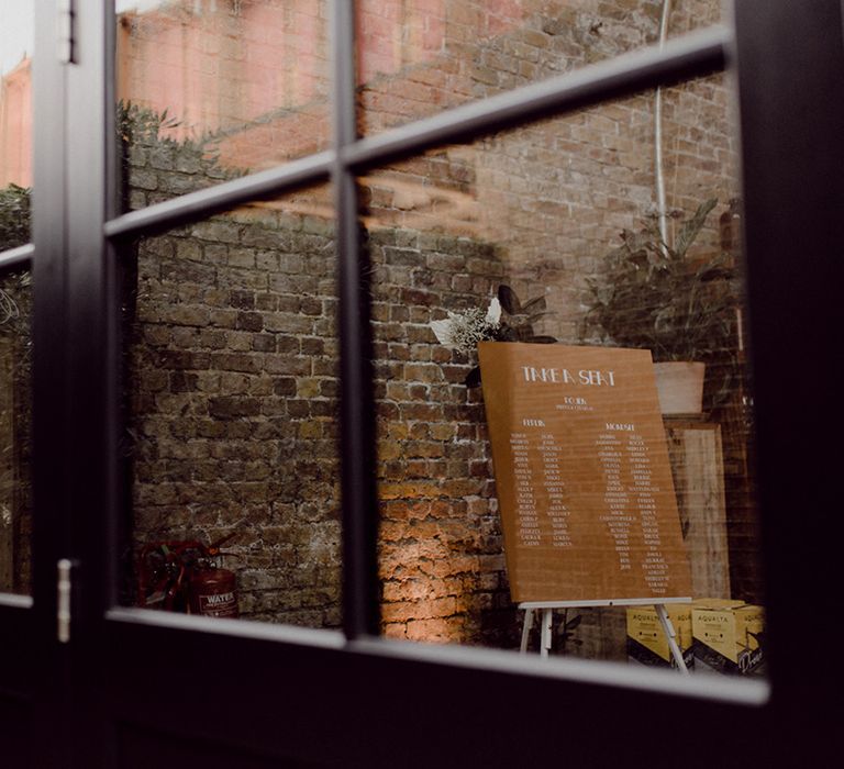 Orange seating chart notice board at the industrial and vintage wedding