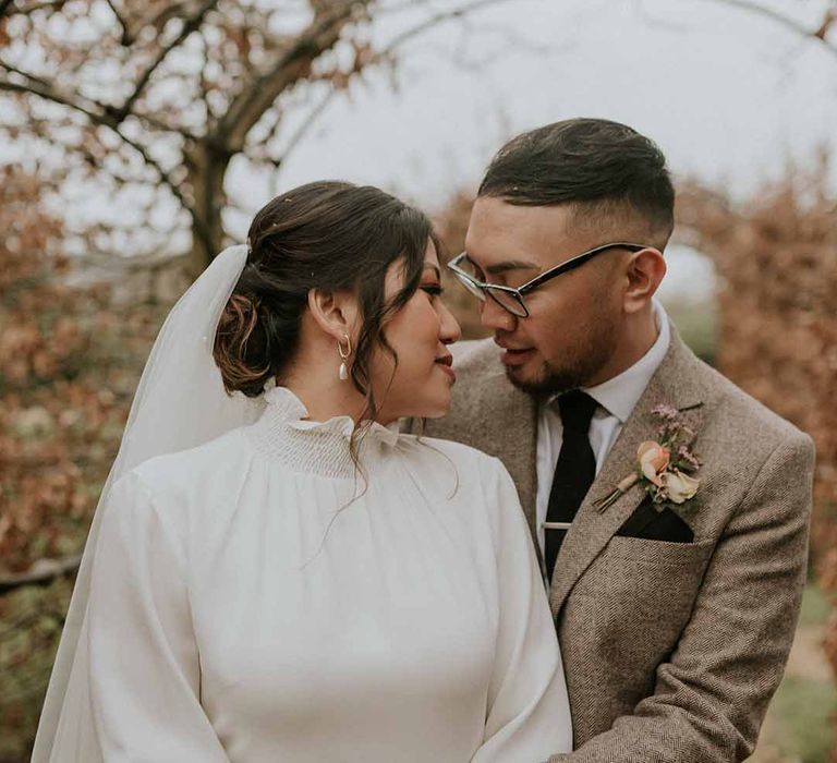 Bride in Vanessa Cocchiaro Paris wedding dress and long white veil and groom in Tru Clothing suit 