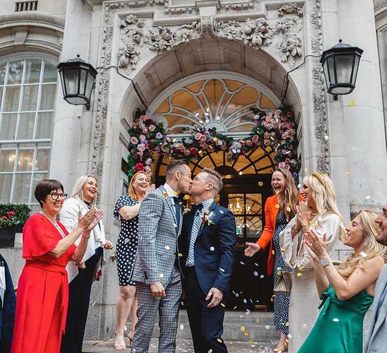 Grooms kiss as confetti is thrown around them