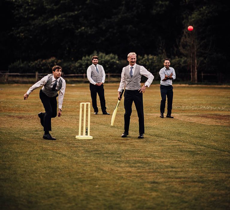 Wedding guests participate in a game of cricket at the cricket club wedding reception venue 