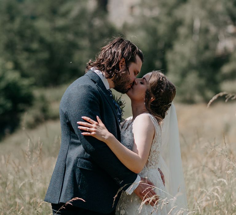 Bride & groom kiss in front of Neidpath Castle in Scotland during classic wedding day