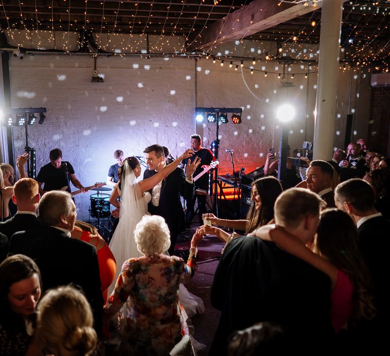 Bride & groom dance during wedding reception at the 100 Barrington as fairy lights sparkle above them