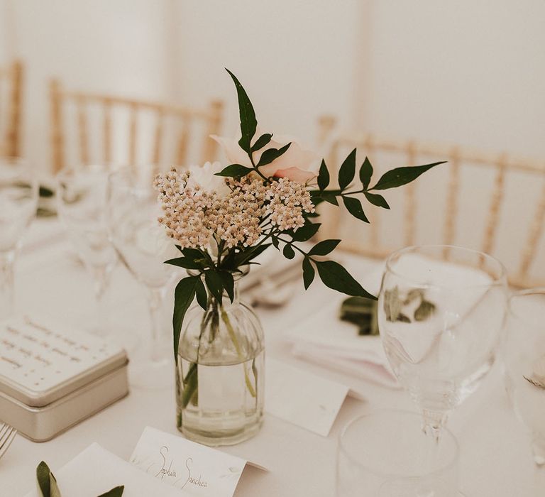 Pink and white mini flower arrangement decorating the white tables 