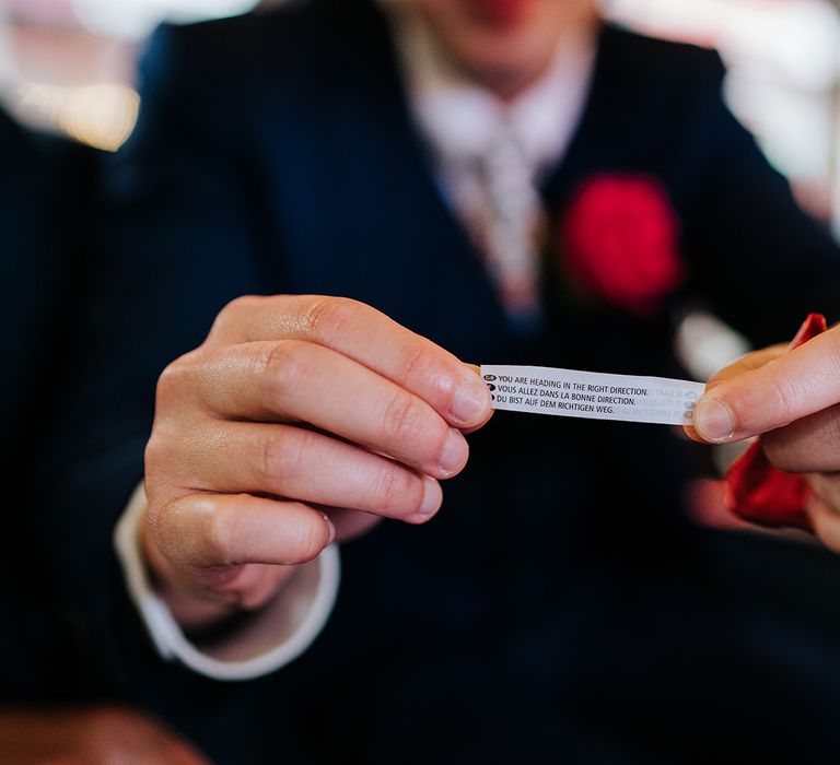 Groom holds fortune cookie fortune 