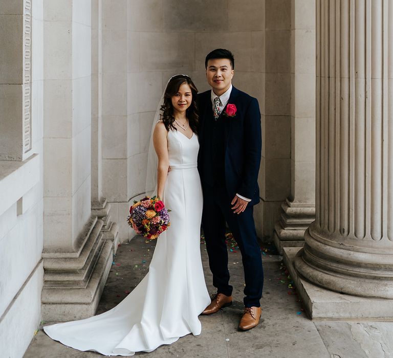 Groom in three-piece suit stands beside his bride at the Old Marylebone Town Hall