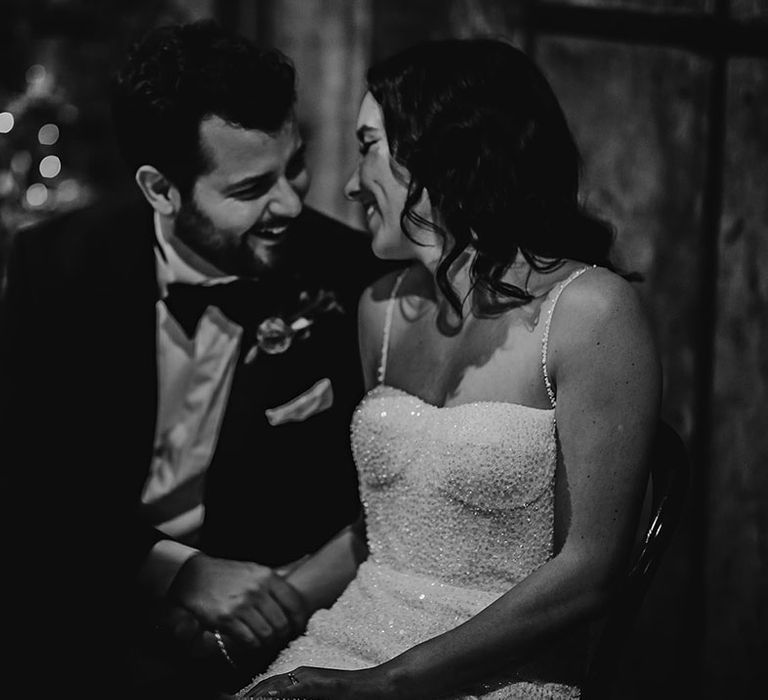 The bride and groom laugh together at their wedding reception 