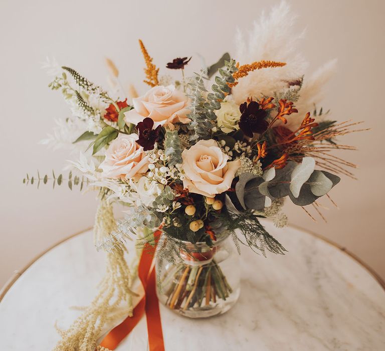 Autumnal styled bridal boutique with pampas grass and tied with orange silk ribbon