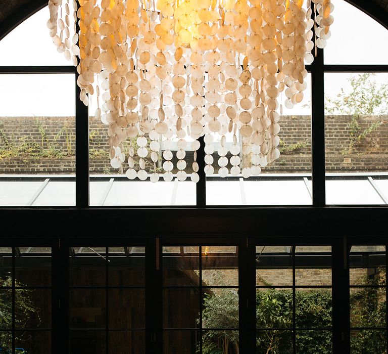 Minimalistic wedding tablescape with black and white table decorations underneath alternative oversized chandelier 