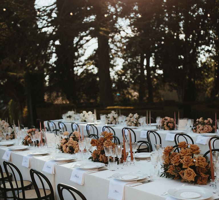 Banquet tables with white tablecloths and floral centrepieces alongside embroidered napkins