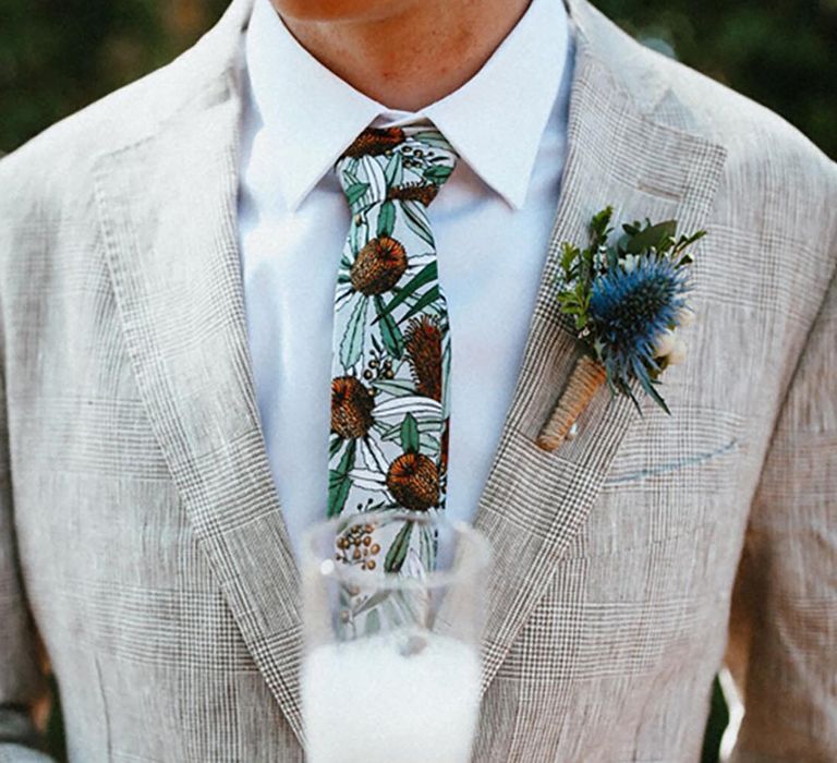 Groom in checkered suit with a funky tie with thistle pattern to match the thistle buttonhole 